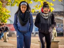 Photo of students walking across campus in late summer.