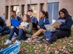 Group of students sitting outside and smiling