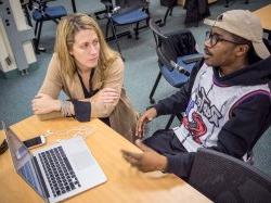 Photo of two students talking in a classroom.