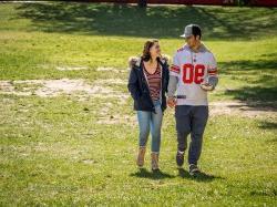 Photo of a man and a woman walking across a field and holding hands