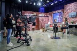 two students at high table on set in front of cameras