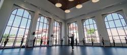 Dancers practicing in front of large windows in large dance studio